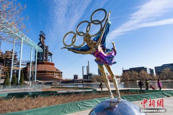 12月1日，位于北京冬奥组委办公区前的一座冬奥主题雕塑在阳光映照下熠熠生辉。 中新社记者 侯宇 摄