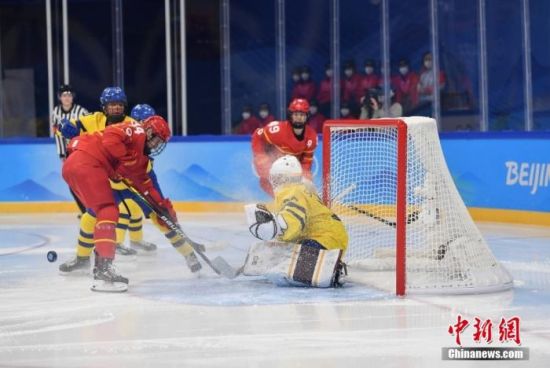2月7日，在五棵松体育中心举行的北京2022年冬奥会女子冰球小组赛中，中国队(红)不敌瑞典队(黄)。图为比赛现场。中新社记者 李骏 摄