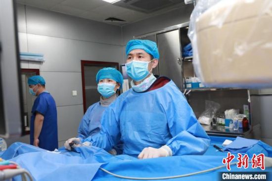 图为程康安(右)开展手术治疗。　青海大学附属医院 供图