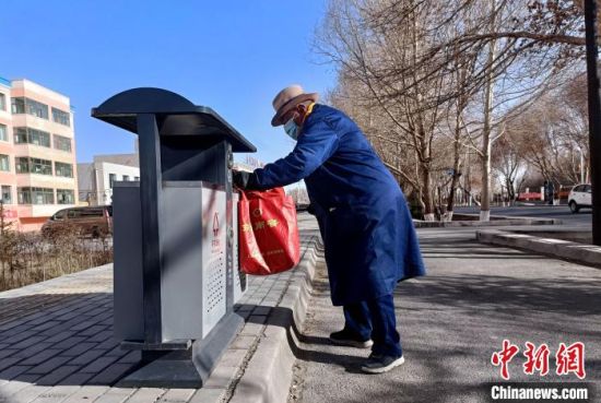 图为昂清老人给临街垃圾桶做清洁。　景桂珍 摄