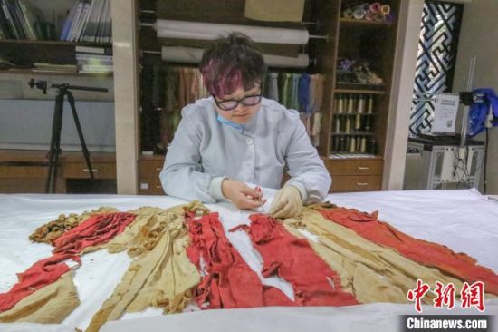 康晓静正在修复纺织品文物。　受访者供图