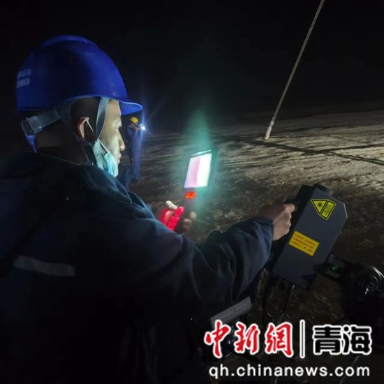 图为国网青海超高压公司输电运检人员连夜前往230多公里外的输电线路现场，及时消除导线上的异物。王磊摄