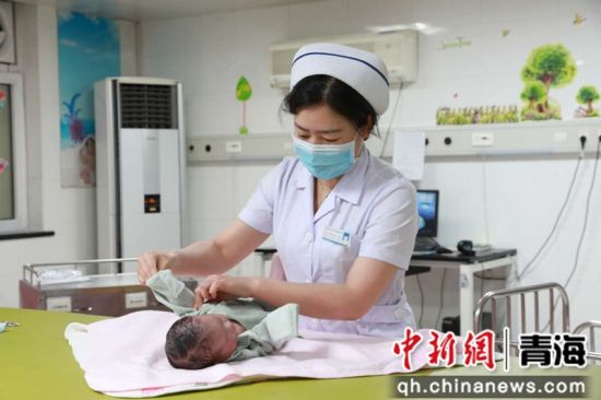 图为疫情期间青海大学附属医院产科医护人员照料新生儿。唐楠摄
