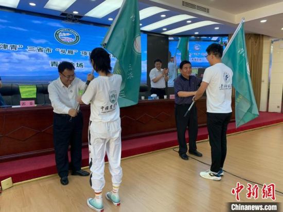 图为领导嘉宾为青海省乡村振兴“雏雁”实践团学生代表授旗。　汪晓青 摄