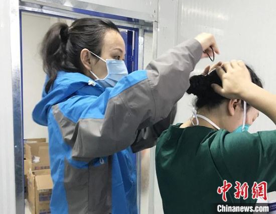 图为祁永芬帮助队员开展防护。　青海省第五人民医院 供图