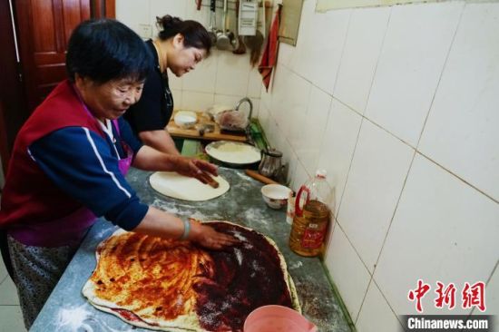 图为何秀兰和女儿刘平正在制作青海传统蒸笼月饼。　马铭言 摄