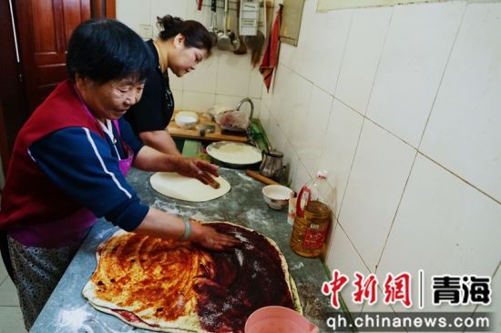 图为何秀兰和女儿刘平正在制作青海传统蒸笼月饼。 马铭言摄