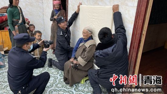 图为华旦和同事为老人照相。兴海县公安局供图
