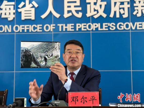 图为青海省林草局副局长邓尔平在新闻发布会上展示雪豹照片。　李江宁 摄