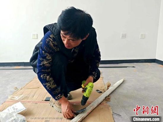 图为祁田林正在修整接待客人的房屋。俞惠珍 摄